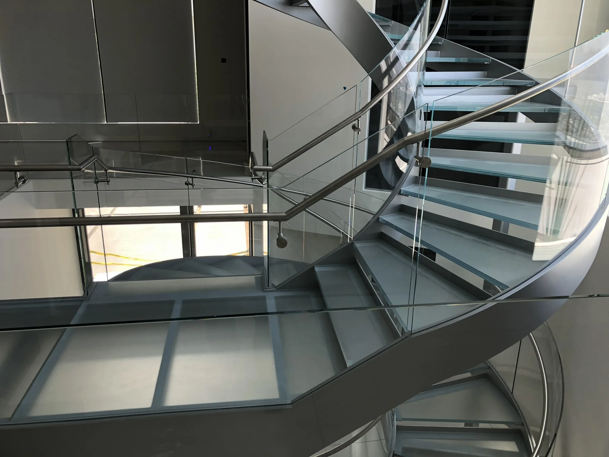 Curved glass railing following a spiral staircase
