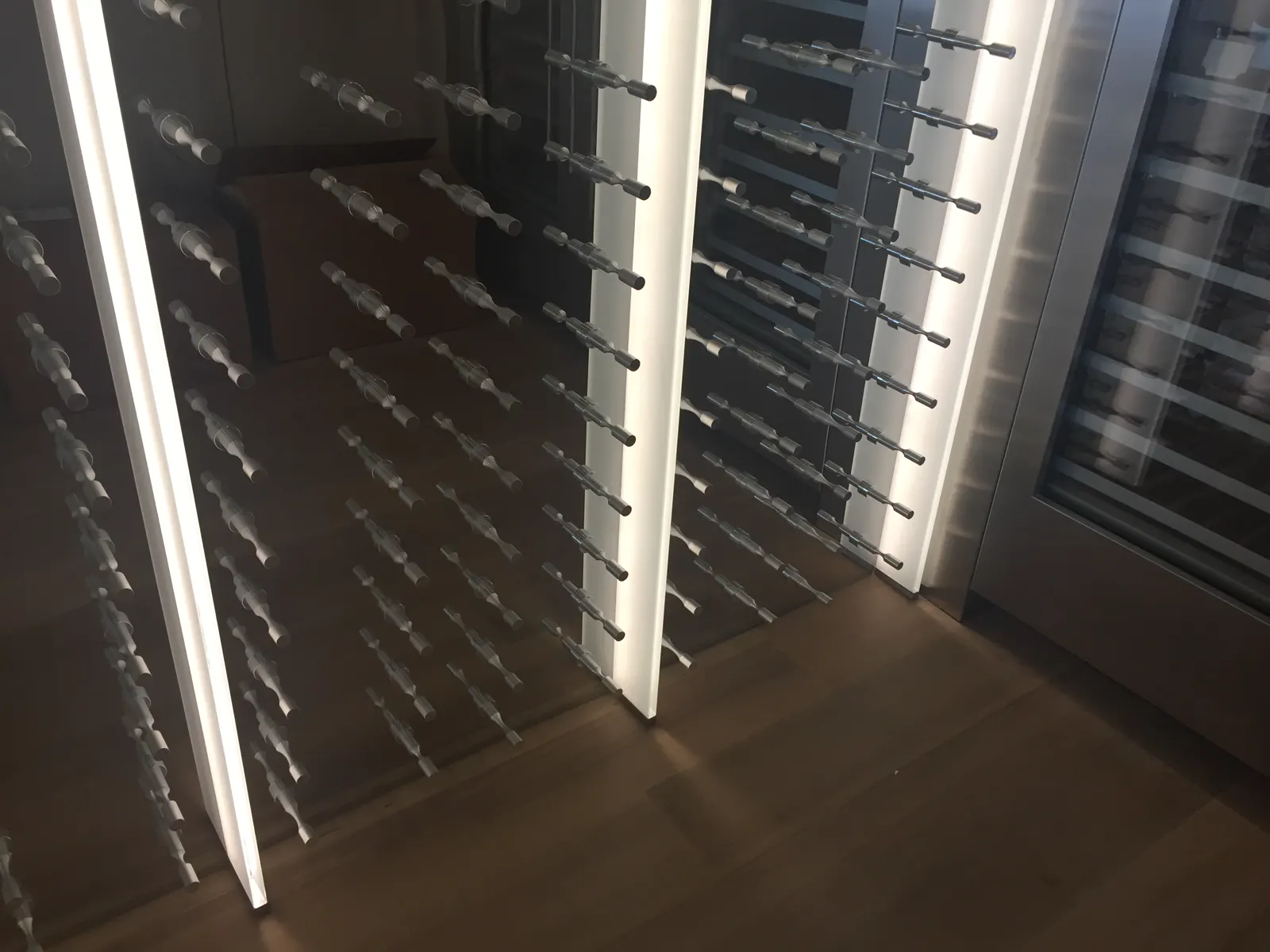 Horizontal metal wine pegs mounted through glass panels