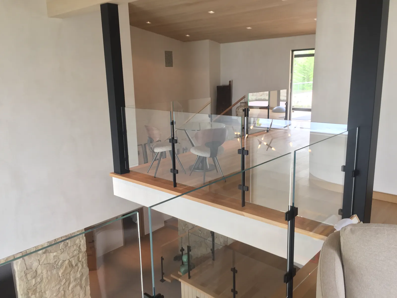 Clear glass railing along an upper-level interior walkway