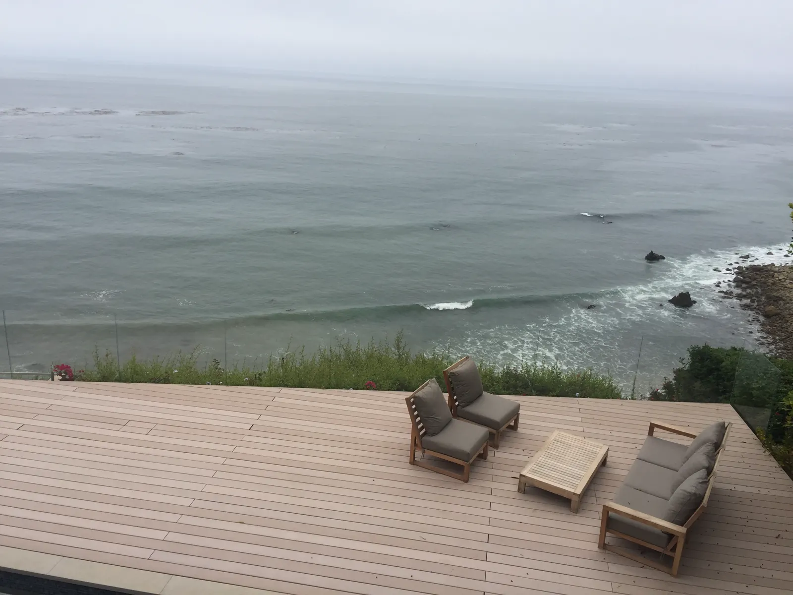 Glass deck railing overlooking a coastal landscape